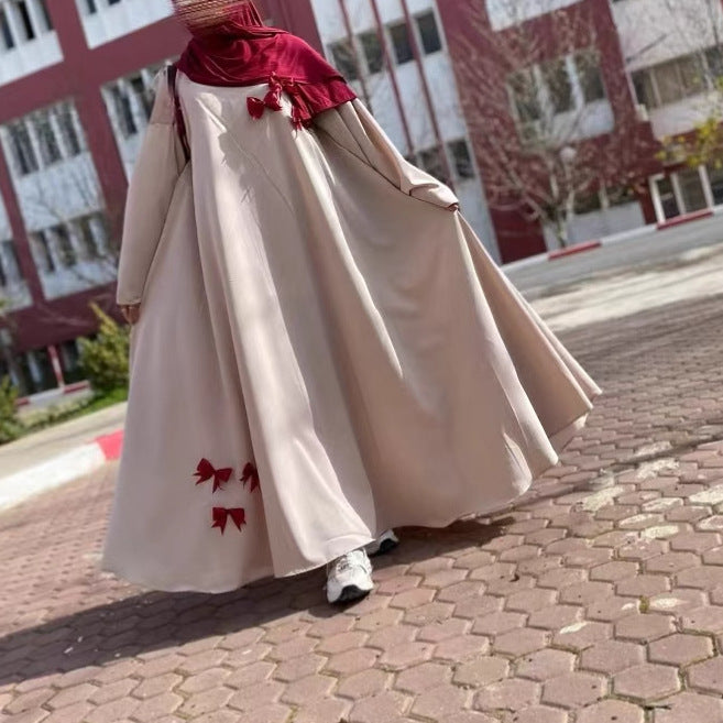 This flowing abaya is designed with delicate bow accents that add a playful yet elegant charm.