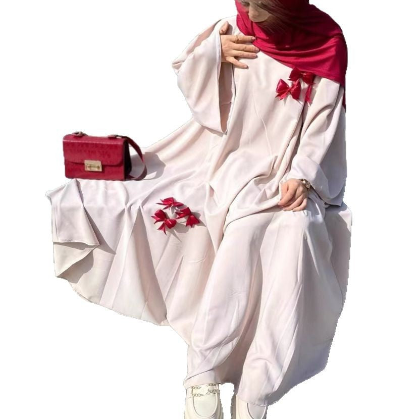 This flowing abaya is designed with delicate bow accents that add a playful yet elegant charm.