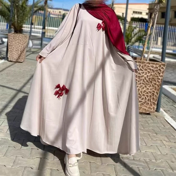 This flowing abaya is designed with delicate bow accents that add a playful yet elegant charm.