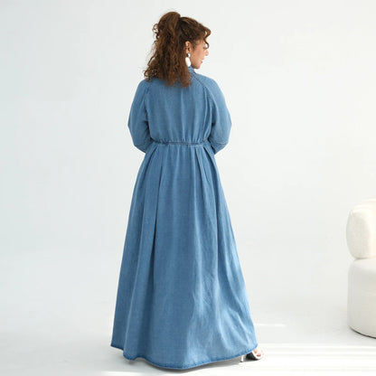 Woman wearing a blue dress standing on a white background