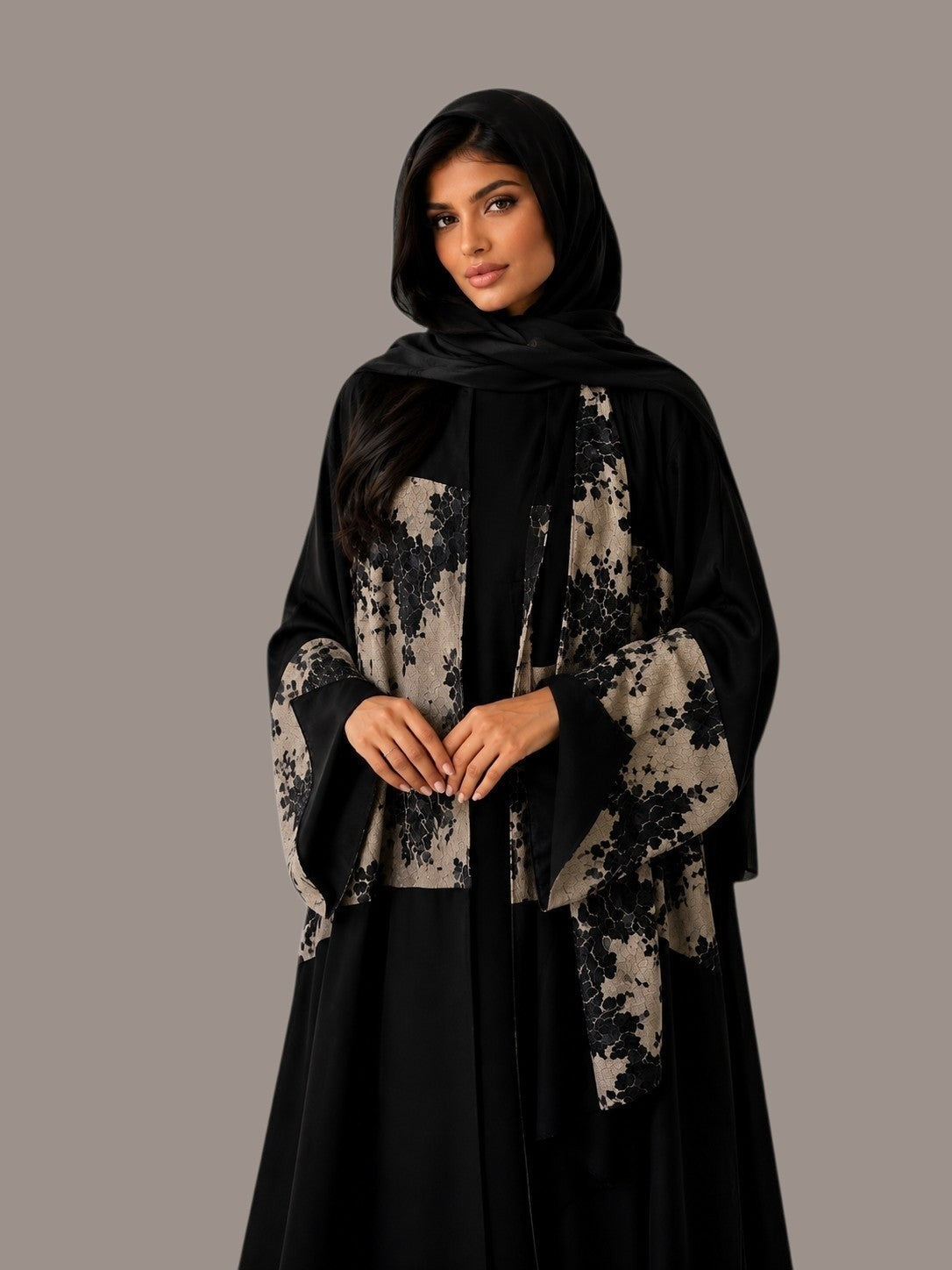 Anab Abaya 2-piece set featuring a black flowing dress with beige floral patterned panels and a matching black hijab.